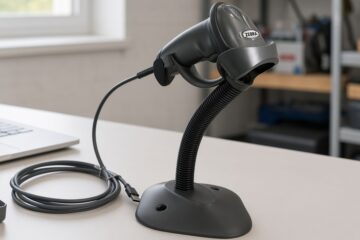 Czarny ręczny skaner Zebra LS2208 w stojaku z kablem USB na biurku serwisowym